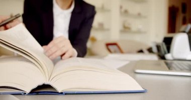 Bir kadının önünde açık bir kitap, okumak, sayfaları çevirmek. Kitap, arka planda, iç mekanda...