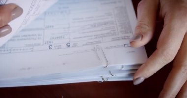 İş kadını ya da muhasebeci elinde kalemle dokümantasyon işi verileri ile birçok belge ters çevrilir ve imzalanır. Ofiste muhasebe belgesi, iş konsepti kapanıyor..
