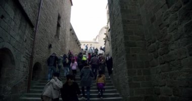 Mont Saint-Michel Manastırı, Mont Saint-Michel Kulesi ve turistler sokaklarda yürüyor. geniş çekim Fransa, 17 Ekim 2019