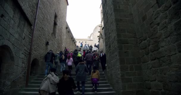 MONT SAINT MICHEL, klostret Mont Saint-Michel tornar och turister går på gatorna. brett skott Frankrike, 17 oktober 2019 — Stockvideo