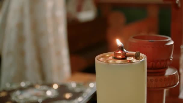 Ζεστό κίτρινο κερί που καίει ήσυχα στην εκκλησία. Μετακίνηση κάμερα. Κλείσε. — Αρχείο Βίντεο