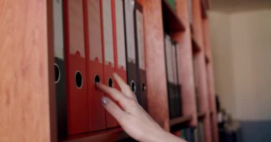 Yaklaştın. Ofis çalışanı ya da muhasebecinin kadın elleri. Belge dizinini çıkarır