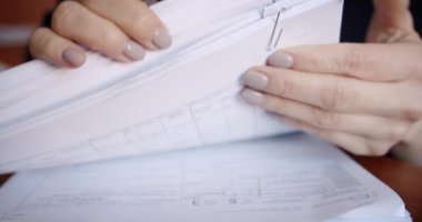 İş kadını ya da muhasebeci el işi belgelerle çalışır iş verileri birçok belge ters çevrilir, iş kavramı kapanır.