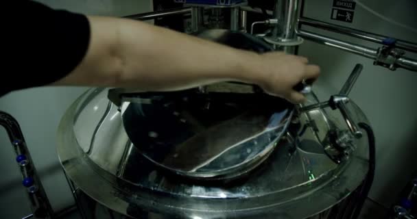 Brewing dark Brewer opent het luik met Bier in de tank voor het brouwen, proces van het maken van bier. Breed schot. Beweeg camera — Stockvideo