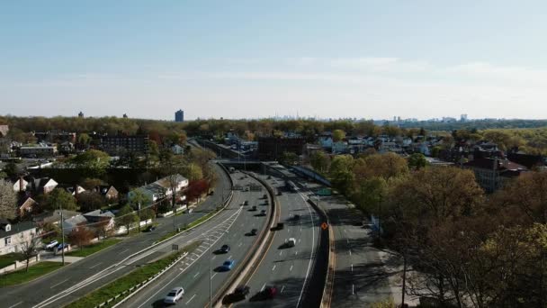 Вид с воздуха на многополосную автомагистраль, ведущую к горизонту Нью-Йорка на горизонте соседних домов в пригороде Йонкерса, с видом на Нью-Йорк — стоковое видео