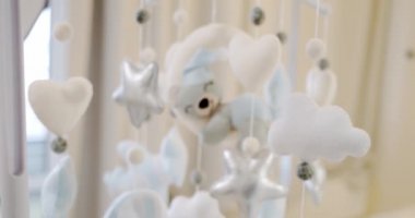 Çocuklar yumuşak oyuncaklar beşik yatağının üzerinde daireler çizerler. Kapatın. Kamerayı taşı