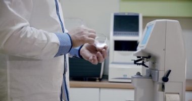 Gözlük yapan göz doktoru objektifi merkezlemek için makineye koyar.