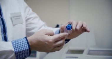 Gözlük yapıyorum, kapat. Göz doktoru bitmiş lensi elinde tutuyor ve optik mağazada inceliyor. Yavaş çekim