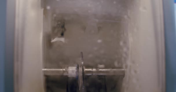 Herstellung von Gläsern, Close up of Machine zum Schleifen und Fräsen von Linsen für Gläser hinter verschlossenem Glas im Optikgeschäft. Zeitlupe — Stockvideo