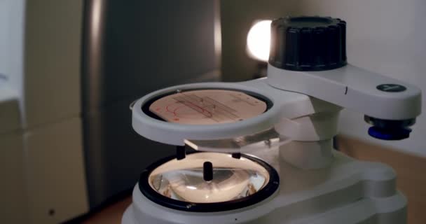 Het maken van glazen, Close-up van de oogarts zet de lens in de machine voor het centreren. V2 — Stockvideo