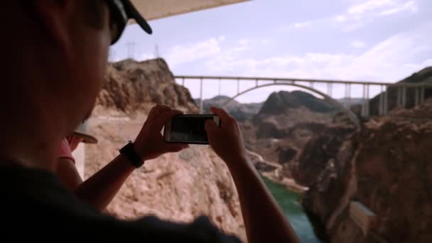 Homem bonito ficar usando celular tirar foto Hoover Dam Arizona EUA — Vídeo de Stock