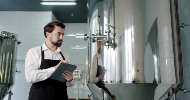 Beer production. Brewery worker checking beverage equipment at brewery or beer plant — Stock Video