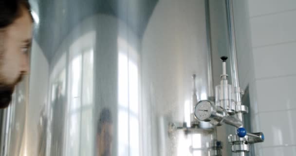Bierproductie. Brouwerij werknemer controleren drank apparatuur in brouwerij of bierfabriek. Sluiten. — Stockvideo