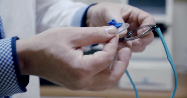 Making glasses, Close up. The ophthalmologist inserts the finished lens into the eyepiece frame in optical store. Slow motion — Stock Video