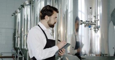 Bira fabrikasındaki veya bira fabrikasındaki içecek ekipmanlarını kontrol eden bir fabrika işçisi. Bira üretimi.