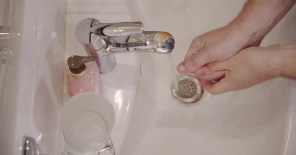 Corona ιός πρόληψη άνθρωπος δείχνει την υγιεινή των χεριών πλύσιμο των χεριών με σαπούνι σε ζεστό νερό. Χρήση διανομέα σαπουνιού — Αρχείο Βίντεο