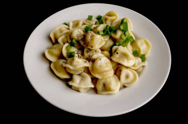 Siyah bir arka plan üzerinde beyaz bir tabak içinde Rus köfte