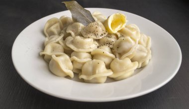 Siyah bir arka plan üzerinde beyaz bir tabak içinde Rus köfte