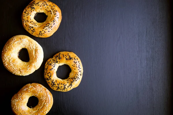 Rosquillas con semillas de sésamo sobre un fondo negro — Foto de Stock