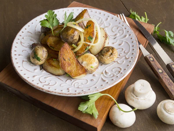 Fried potatoes with mushrooms, onions, parsley. — Stock Photo, Image