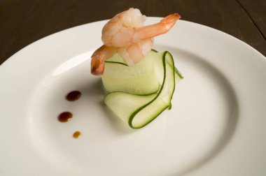 ince dilimlenmiş salatalık beyaz bir plaka üzerinde