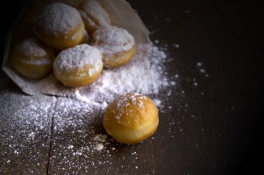 yuvarlak çörekler bir kağıt torba ile toz serpilir