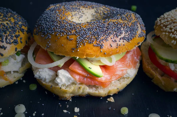 Bagels with cream cheese and smoked salmon on a black background — Stock Photo, Image