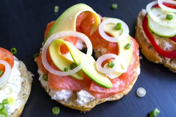 Bagels with cream cheese and smoked salmon on a black background — Stock Photo, Image