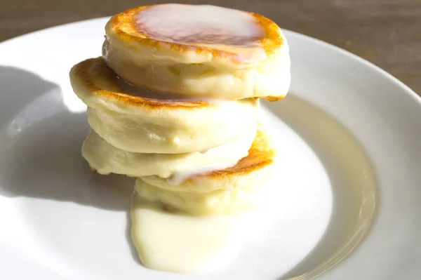 Keso pannkakor på en vit platta. Frukost på en solig morgon — Stockfoto