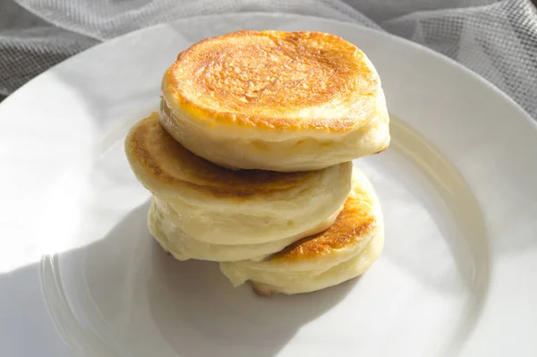 Keso pannkakor på en vit platta. Frukost på en solig m — Stockfoto