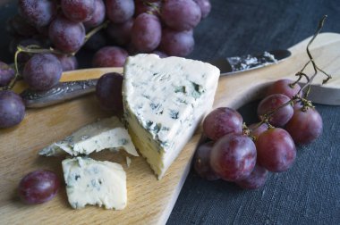 Dorblu peynir ahşap tahta üzerinde üzüm ile