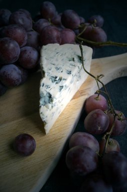 Dorblu peynir ahşap tahta üzerinde üzüm ile