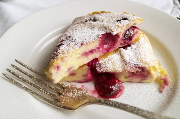 Cheesecake ile çilek, kiraz. Beyaz bir plaka üzerinde