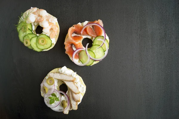 Bagels with cream cheese and smoked salmon on a black background — Stock Photo, Image