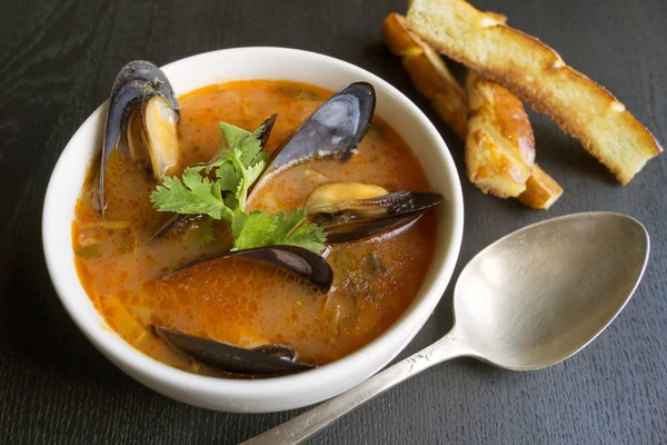 Midye ile domates çorbası. Üzerinde siyah bir backgro ile kızarmış kruton