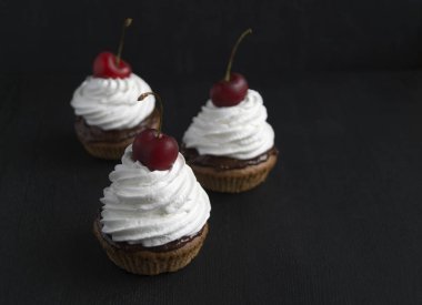 Siyah bir zemin üzerine krema ile sünger kek.