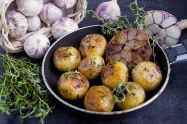 Sarımsak ve kekik ile bir tavada kızarmış patates.