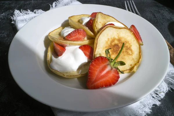 Pancakes with strawberries and sour cream. on a black background — Stock Photo, Image
