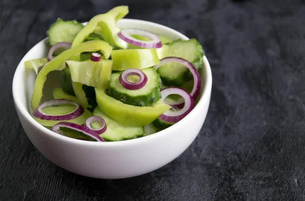Saláta, friss zöldségek, a fekete háttér. — Stock Fotó
