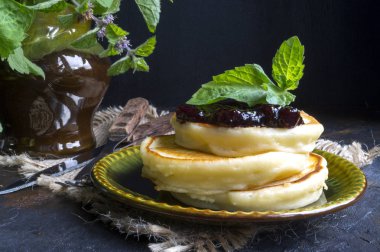 Bir yığın krep reçel ve nane ile bir plaka üzerinde.