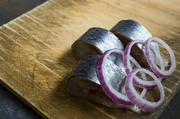 Pieces of herring with a purple bow on the Board. — Stock Photo, Image