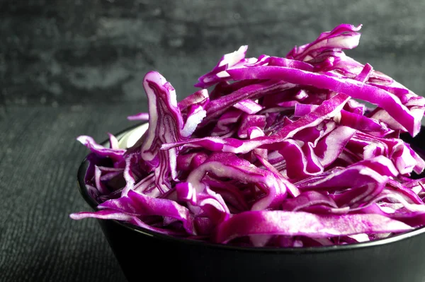 Sliced cabbage in a black bowl. — Stock Photo, Image