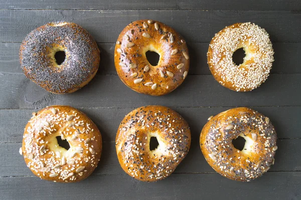 Bagels with seeds on a black background. — Stock Photo, Image