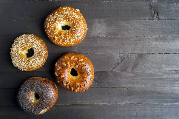 Bagels with seeds on a black background. — Stock Photo, Image