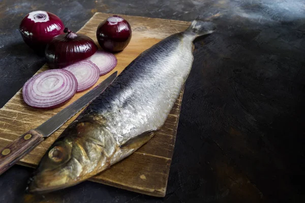 Herring on a chopping Board with onions. — Stock Photo, Image