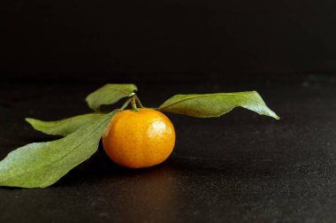 Siyah arka planda olgun mandalinalar.