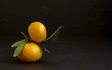 Siyah arka planda olgun mandalinalar.