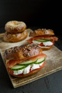 Simit krem peynir ve siyah bir arka plan üzerinde füme somon ile