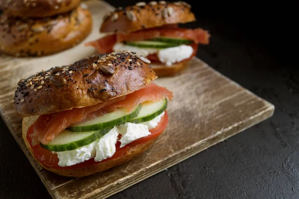 Bagels with cream cheese and smoked salmon on a black background — Stock Photo, Image
