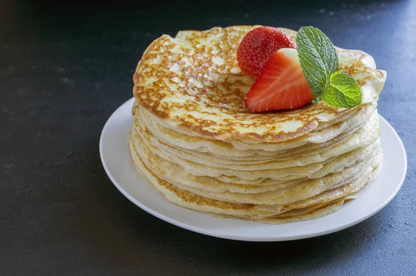 Panqueques con fresas y menta sobre fondo negro . — Foto de Stock